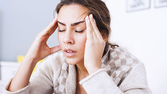 Woman suffering from headache before visiting Concord chiropractor